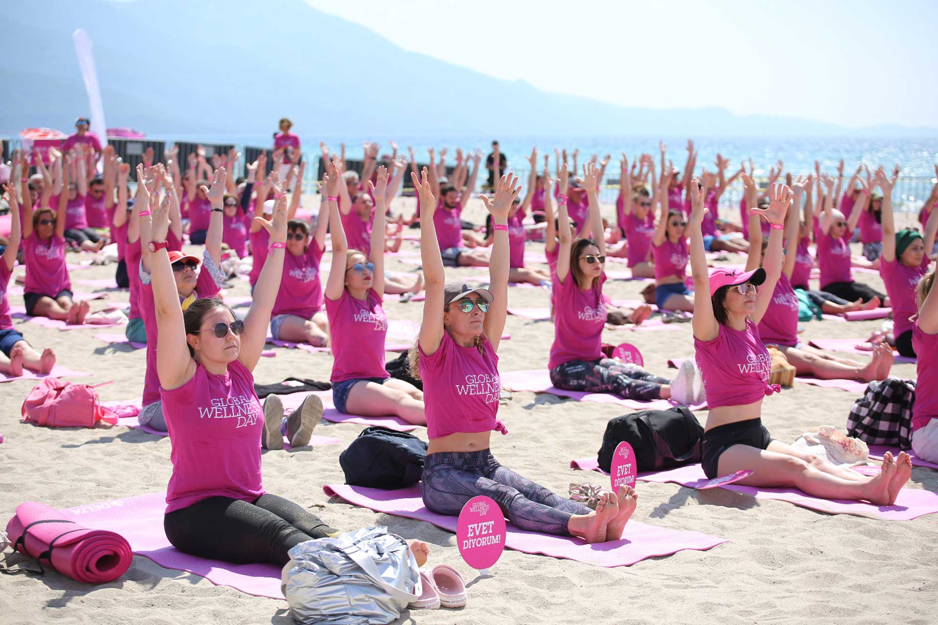 Group of people in pink dress doing yoga